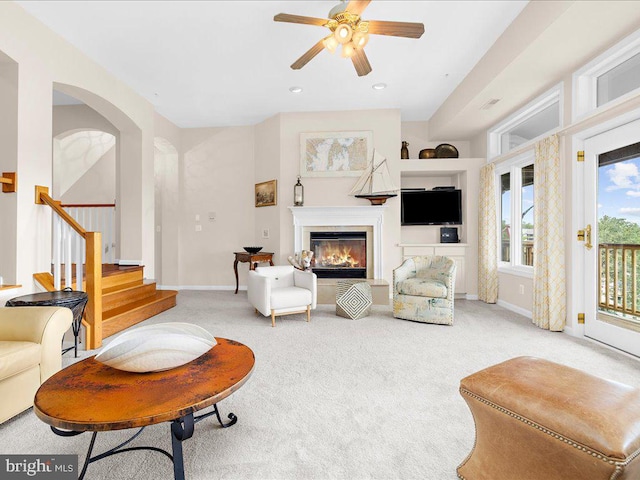 carpeted living room with ceiling fan