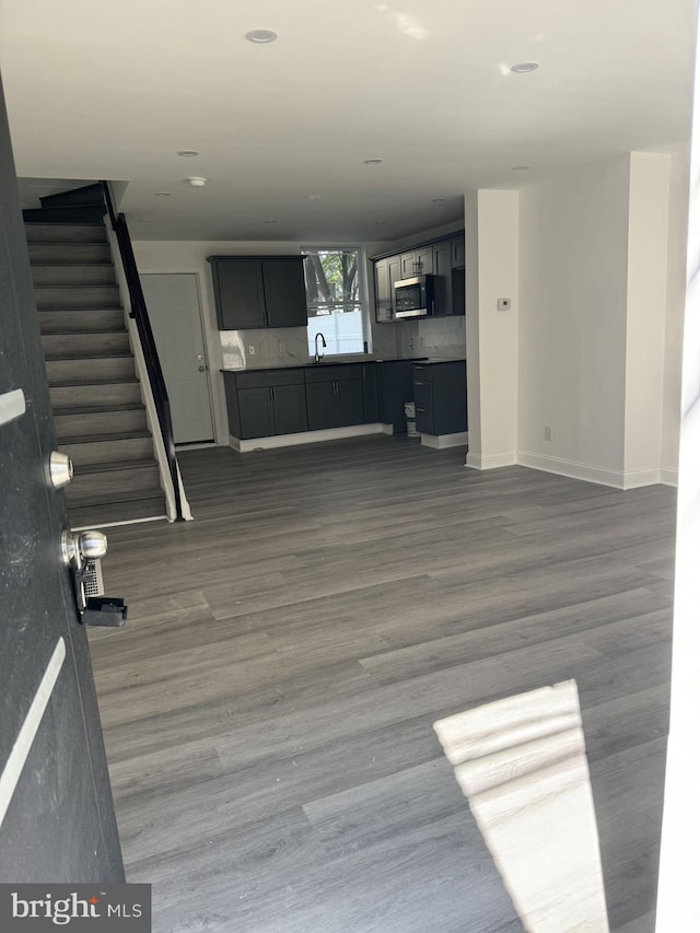 unfurnished living room with dark hardwood / wood-style floors and sink