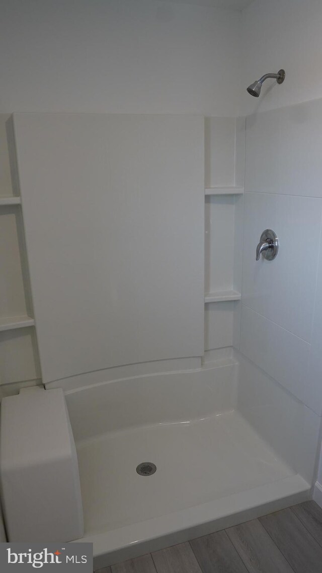 bathroom with a shower and hardwood / wood-style flooring