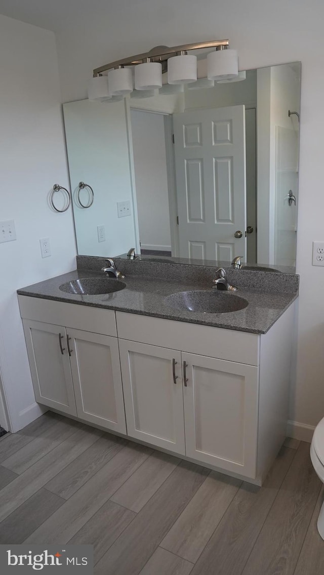 bathroom featuring vanity, toilet, and hardwood / wood-style flooring