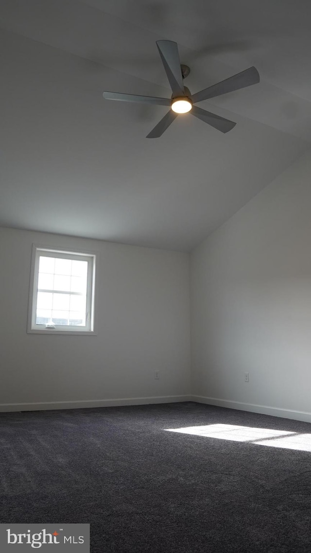 carpeted empty room with ceiling fan and lofted ceiling