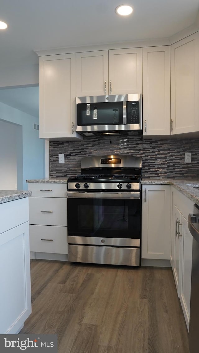 kitchen featuring light stone countertops, dark hardwood / wood-style flooring, stainless steel appliances, and white cabinets