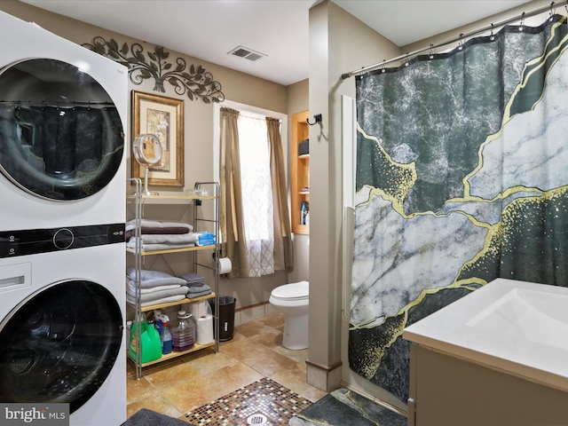 bathroom with a shower with curtain, toilet, vanity, and stacked washer and clothes dryer