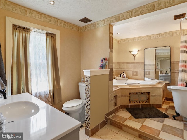 bathroom featuring vanity, a textured ceiling, a washtub, toilet, and tile patterned floors