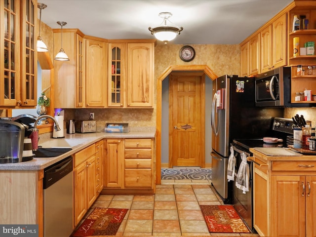 kitchen featuring appliances with stainless steel finishes, light tile patterned flooring, backsplash, pendant lighting, and sink