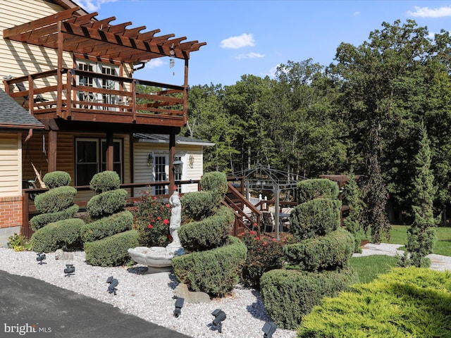 view of front of property with a pergola and a wooden deck