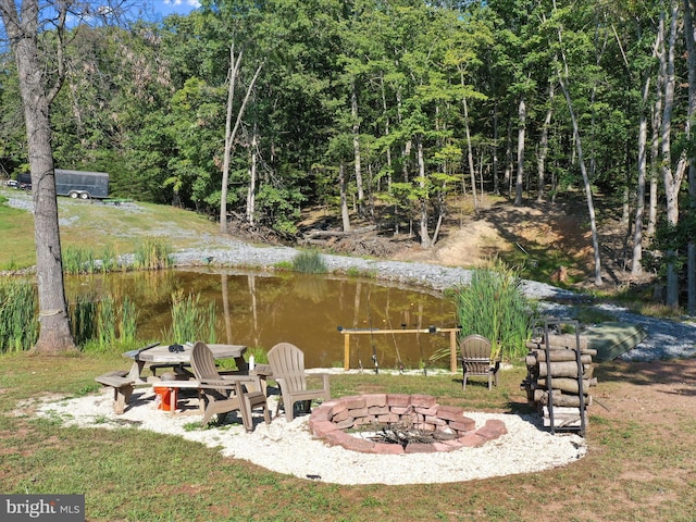 view of yard featuring a water view and a fire pit