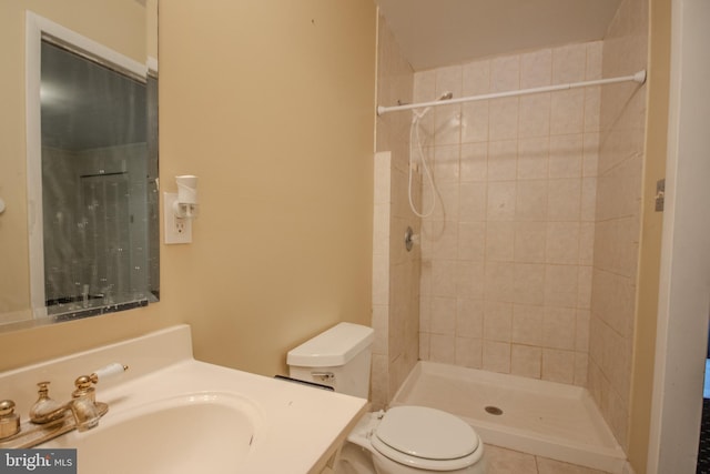 bathroom featuring tiled shower, vanity, toilet, and tile patterned flooring