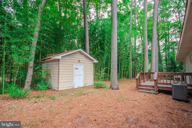 exterior space with a storage shed, a deck, and central AC