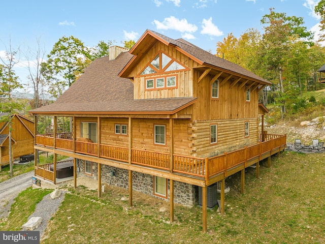 back of property featuring a deck, a lawn, and central air condition unit