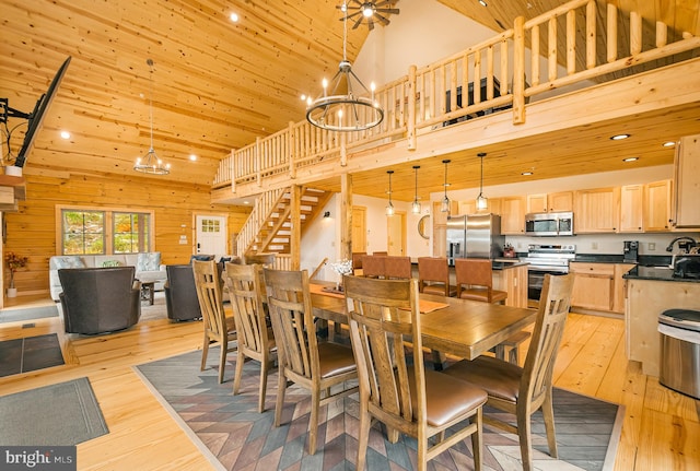 dining area featuring wood ceiling, wood walls, light hardwood / wood-style flooring, a chandelier, and high vaulted ceiling