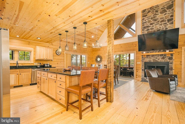 kitchen featuring a stone fireplace, a kitchen breakfast bar, and plenty of natural light