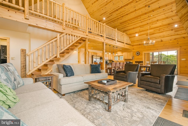 living room with hardwood / wood-style flooring, wood walls, high vaulted ceiling, an inviting chandelier, and wooden ceiling