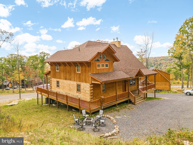 view of side of home with central AC unit, a fire pit, and a deck