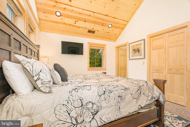 carpeted bedroom with a closet, wood ceiling, and vaulted ceiling