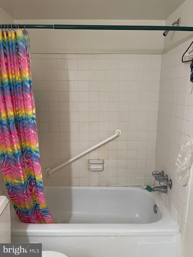 bathroom with shower / bath combination with curtain and toilet