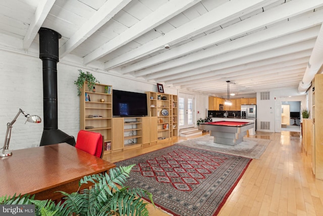 recreation room featuring beam ceiling, a wood stove, light wood-type flooring, and billiards