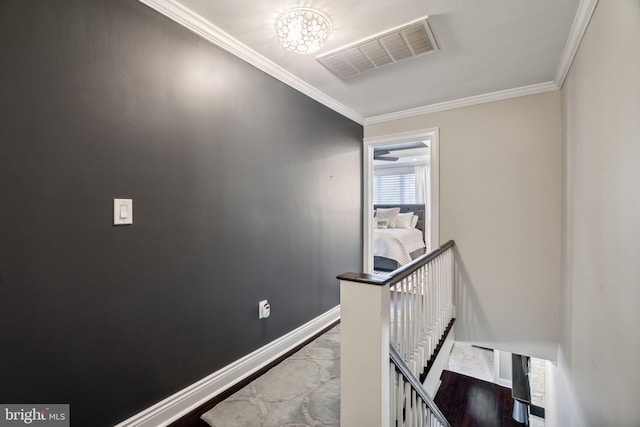 corridor featuring crown molding, hardwood / wood-style flooring, and a chandelier