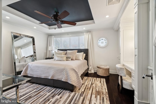 bedroom with ceiling fan, multiple windows, a tray ceiling, and dark hardwood / wood-style flooring