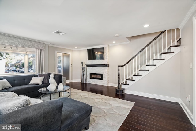 living room featuring a stone fireplace, crown molding, and hardwood / wood-style floors