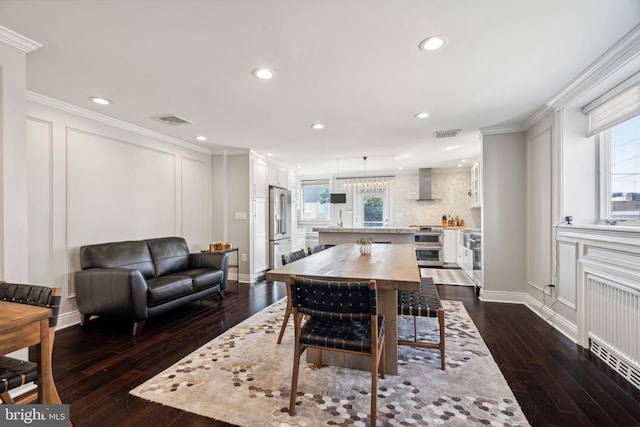 dining area with dark wood-type flooring, crown molding, and a healthy amount of sunlight