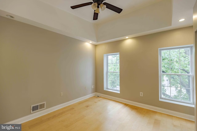 unfurnished room with a wealth of natural light, ceiling fan, and light wood-type flooring