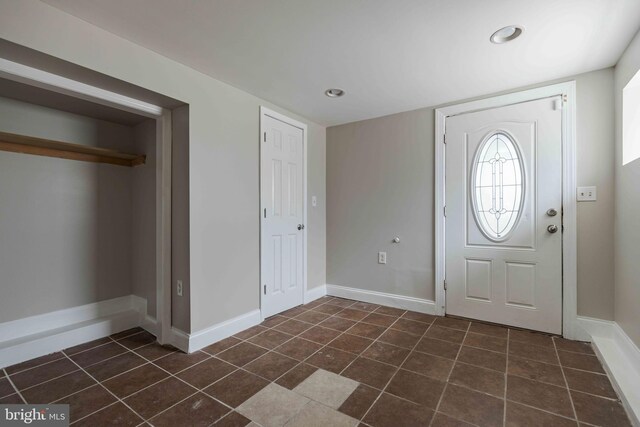 foyer featuring dark tile patterned flooring