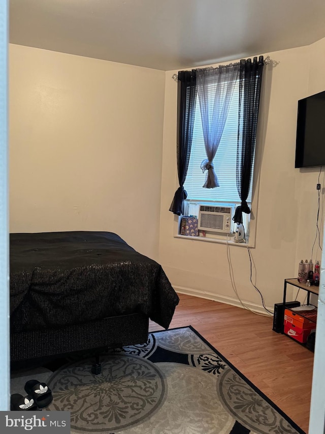 bedroom with wood-type flooring and cooling unit