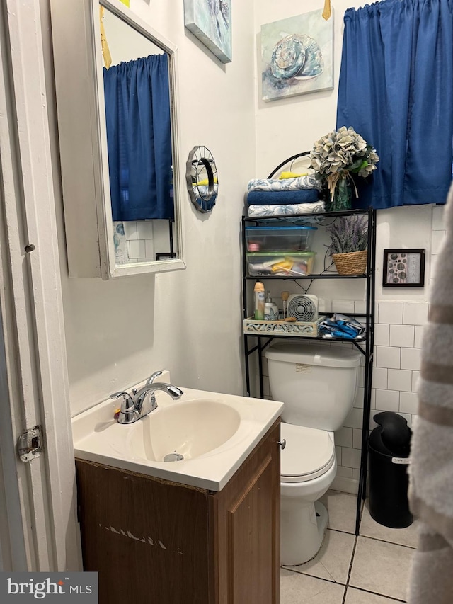 bathroom with tile walls, tile patterned floors, vanity, and toilet