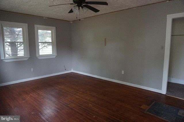 unfurnished room with a textured ceiling, dark wood-type flooring, and ceiling fan