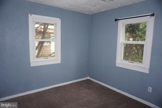 carpeted spare room with a textured ceiling