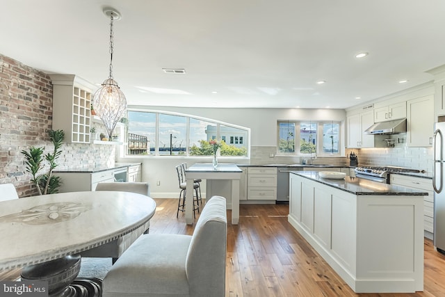 kitchen featuring white cabinetry, light hardwood / wood-style floors, and a center island