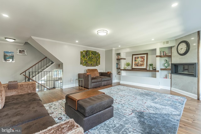 living room with crown molding and light wood-type flooring