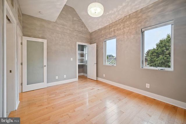 unfurnished bedroom with light hardwood / wood-style flooring and high vaulted ceiling