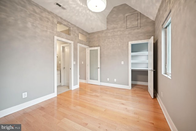 unfurnished bedroom featuring high vaulted ceiling and light hardwood / wood-style floors