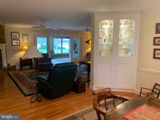 living room featuring ceiling fan, crown molding, and light hardwood / wood-style floors