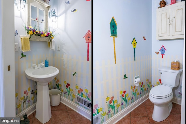 bathroom with toilet, sink, and tile patterned floors