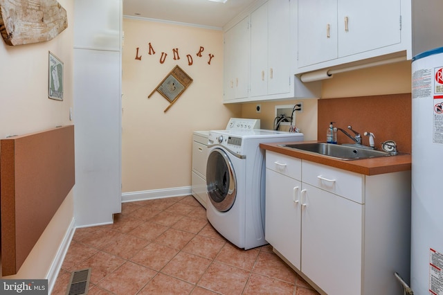 clothes washing area featuring light tile patterned flooring, independent washer and dryer, gas water heater, cabinets, and sink