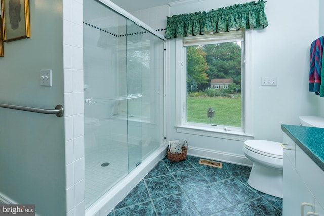 bathroom featuring vanity, toilet, and a shower with door