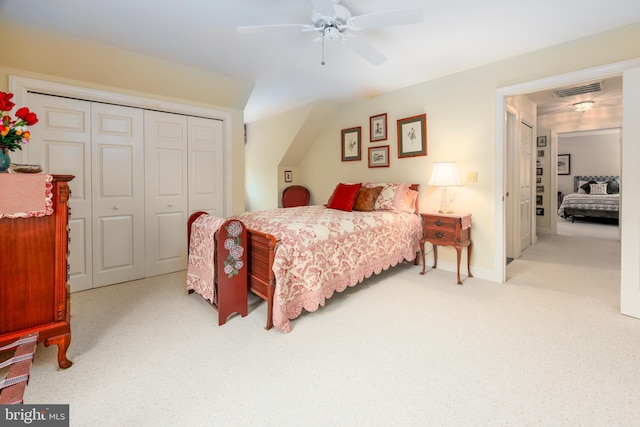 bedroom with ceiling fan, light colored carpet, and a closet