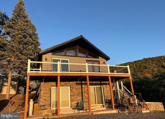 1604 High Knob Rd, Old Fields, WV 26845 - rear view of property featuring a deck, stone siding, stairs, and a forest view