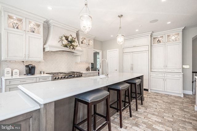 kitchen with a large island, stainless steel gas cooktop, hanging light fixtures, and decorative backsplash