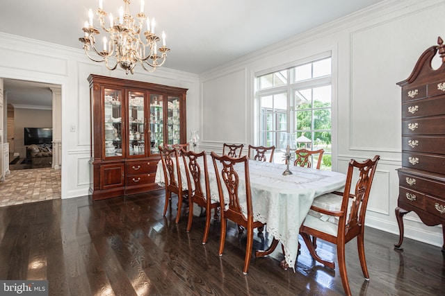 dining area with ornamental molding, a notable chandelier, and dark hardwood / wood-style floors