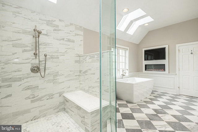 bathroom featuring shower with separate bathtub and vaulted ceiling with skylight