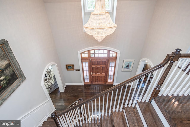 foyer featuring a notable chandelier, a towering ceiling, and hardwood / wood-style flooring