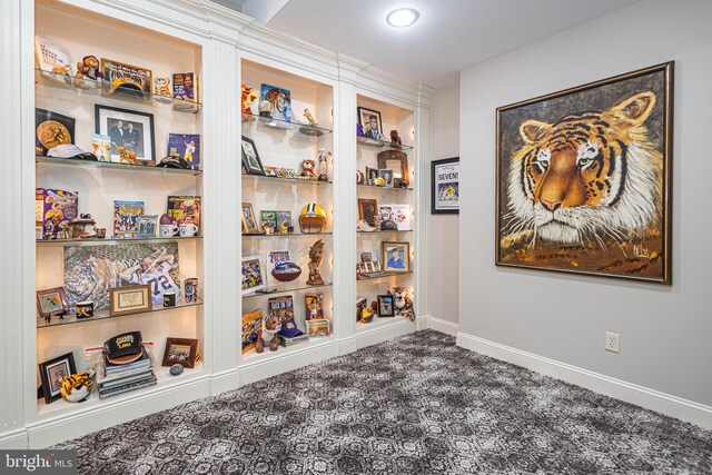 spare room featuring dark colored carpet