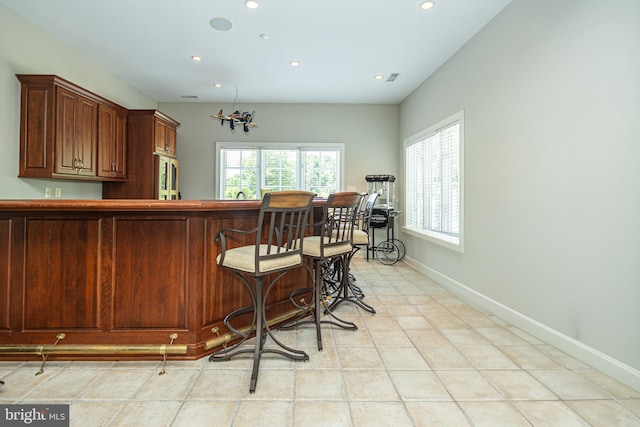 interior space with a kitchen bar and light tile patterned floors