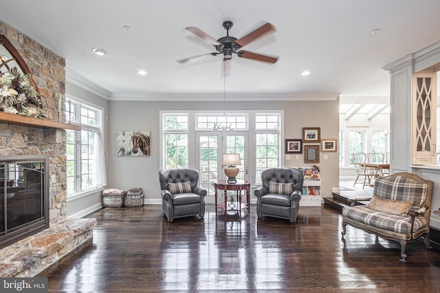 living room featuring a fireplace, ornamental molding, dark hardwood / wood-style floors, and ceiling fan