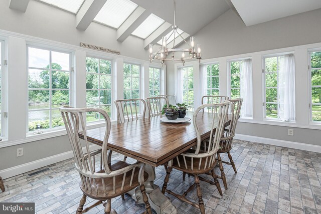 dining room featuring vaulted ceiling with skylight, a chandelier, and a wealth of natural light