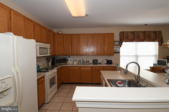 kitchen with sink, white appliances, and light tile patterned floors